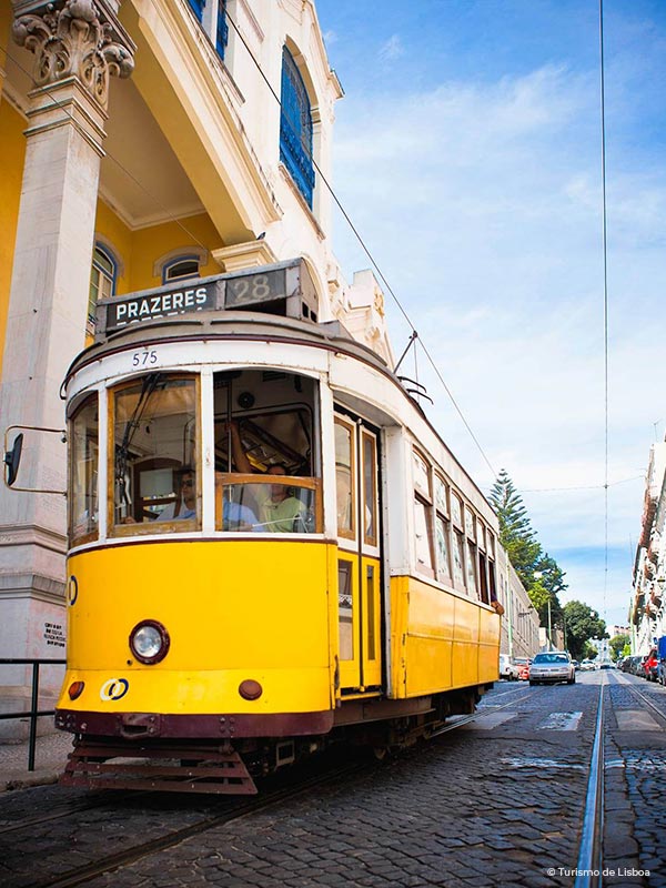 Yellow tram number 28 in Lisbon, Portugal, on a sunny day.