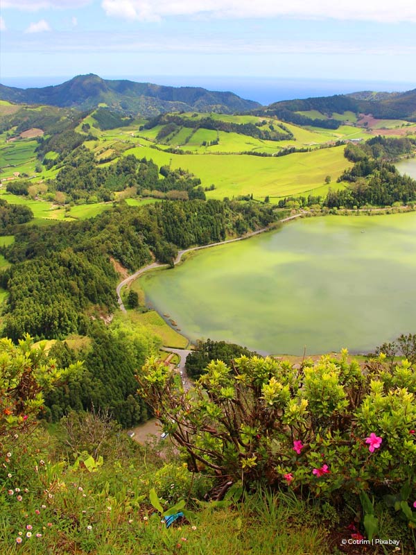 View of Sao Miguel in Azores with lake and green hills and flowers