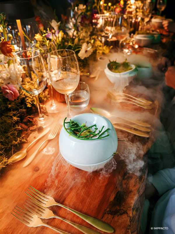 Elegant and exquisite dinner table decorated with flowes, candles, glassware and golden tableware, with elegant plates from high cuisine.